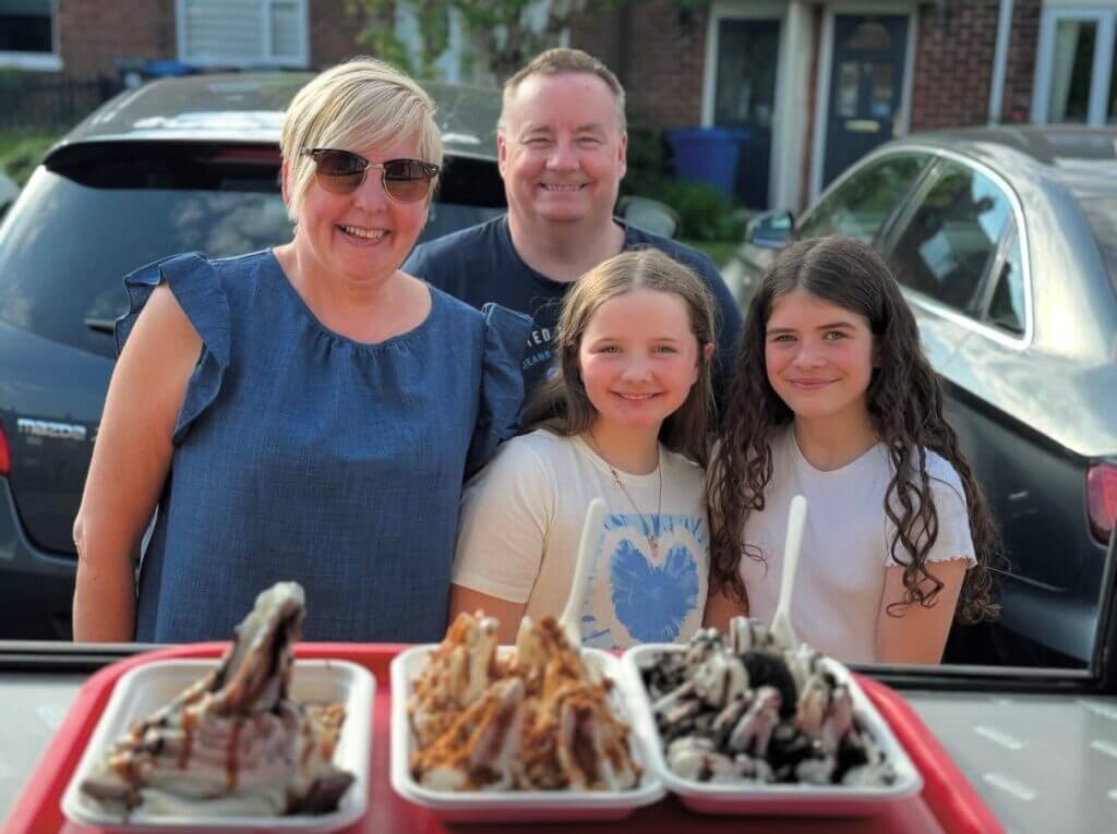 Family of four smiling, looking forward with their order of shez whippy Crunchie Blast,Creamy Fudgie Brownie Smile, Oreo Dreamy Creams