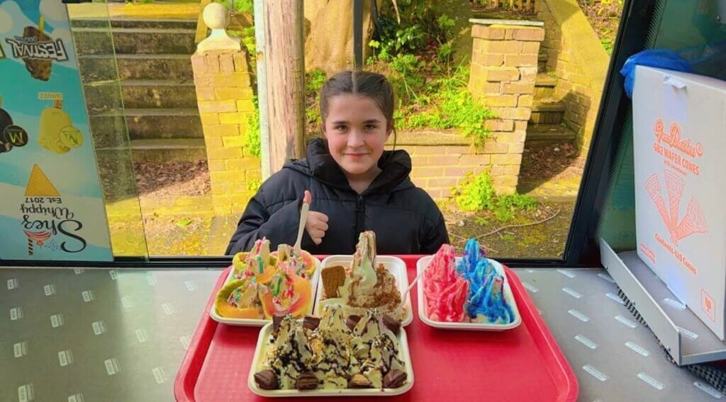Young girl doing thumbs up with her served ice cream trays by shez whippy on the streets of manchester