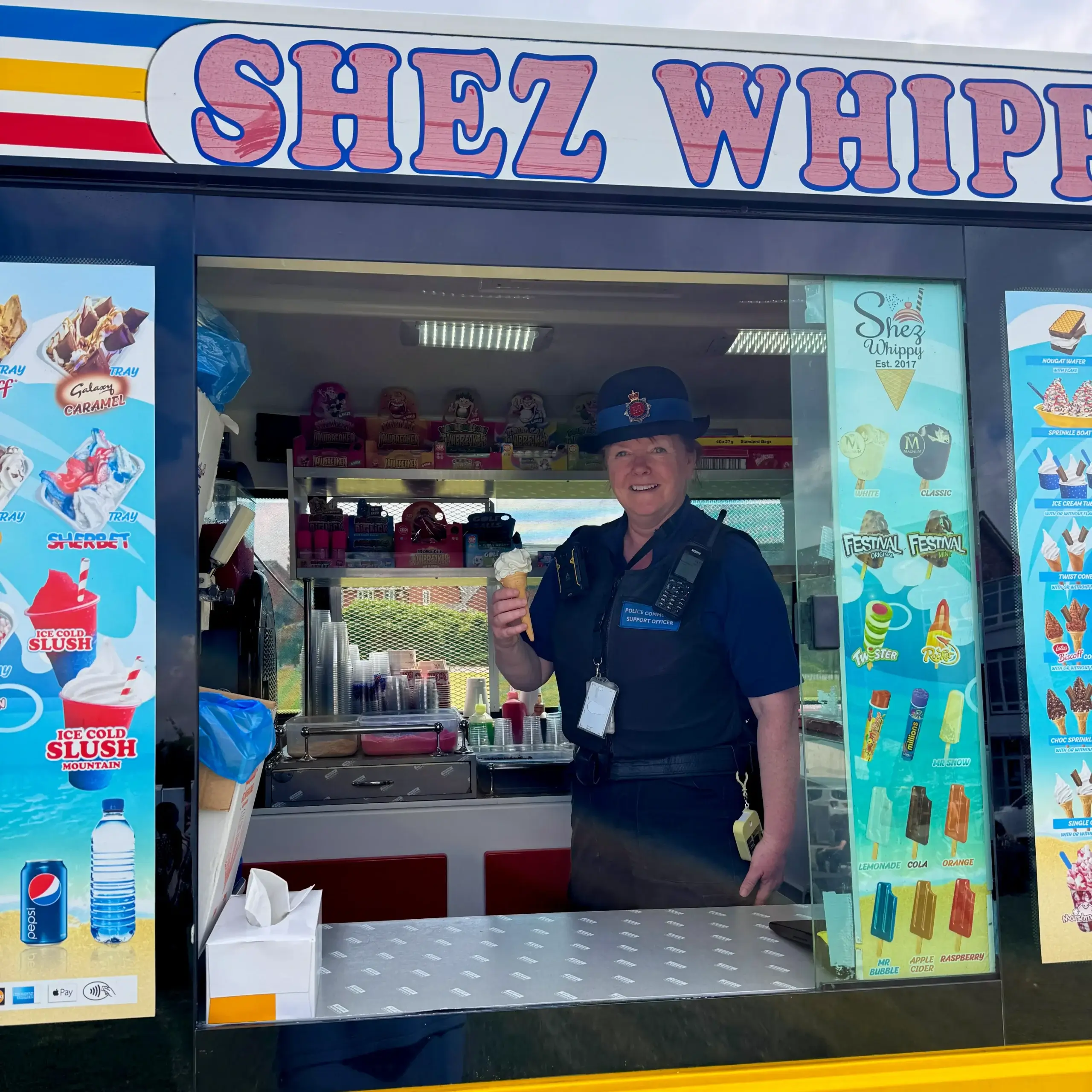 Police Officer holding Ice Cream inside Shez Whippy Van on a community event in Bury, Greater Manchester