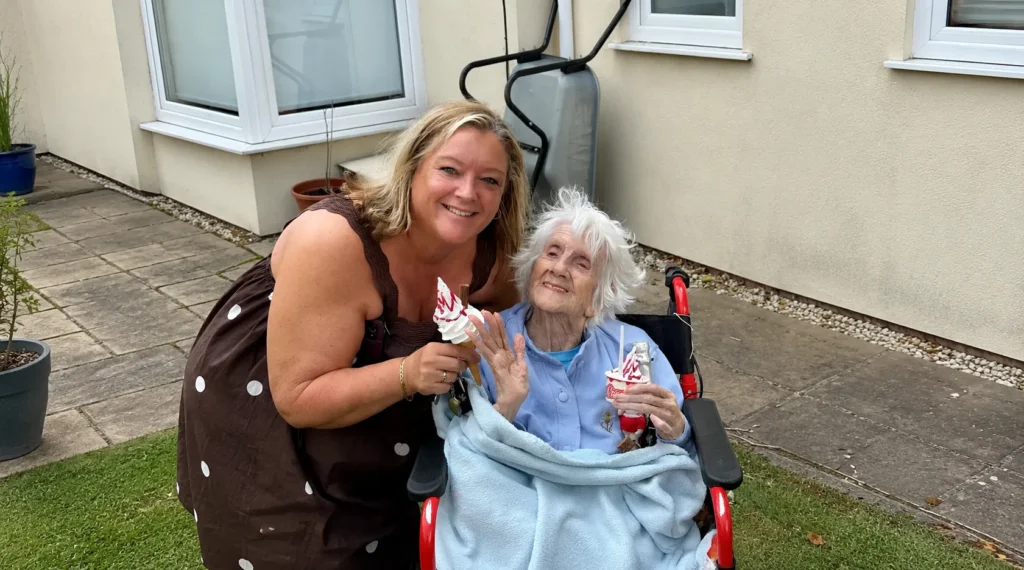 Shez Whippy serving ice cream to elderly on Holly Bank Nursing Home Community event in Radcliffe