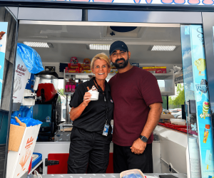 Mr Shez standing alongside a customer holding whippy ice cream tub in her hand on the shez whippy van